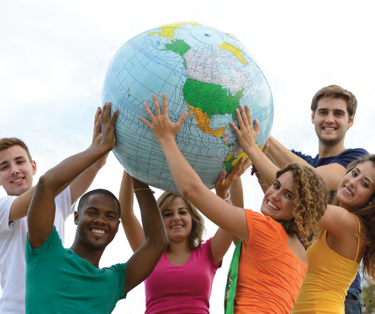 Young people holding up an inflatable globe together