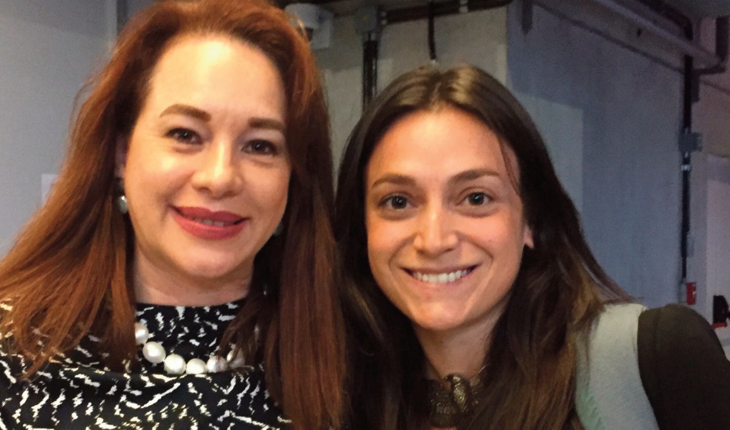Two women smiling together at an event.