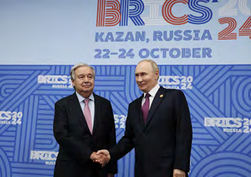 UN Secretary General Antonio Guterres shakes hands with Vladimir Putin at the BRICS 2024 summit in Kazan