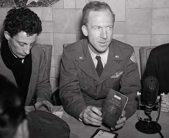 Garry Davis holds a World Passport at a press microphone