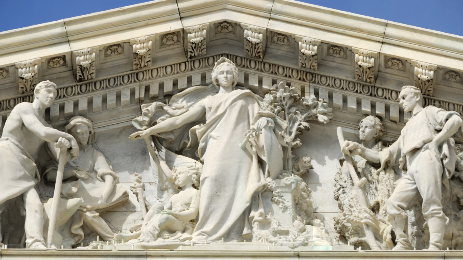Allegorical marble figures in the pediment of a neoclassical government building
