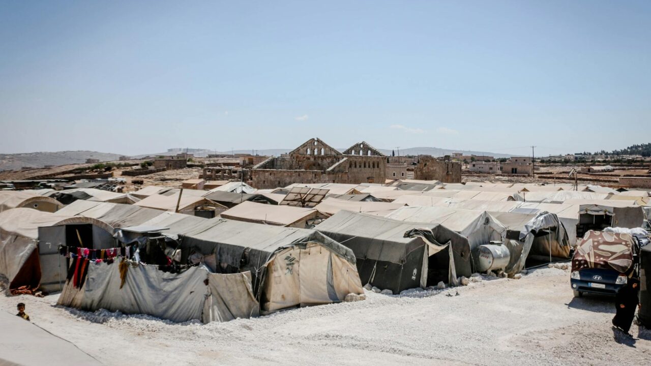 A view of a refugee camp with tents set up for displaced persons, indicating the need for humanitarian assistance.