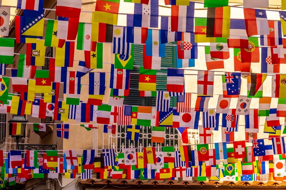 A collection of international flags hanging together in a row, symbolizing unity and diversity among nations.