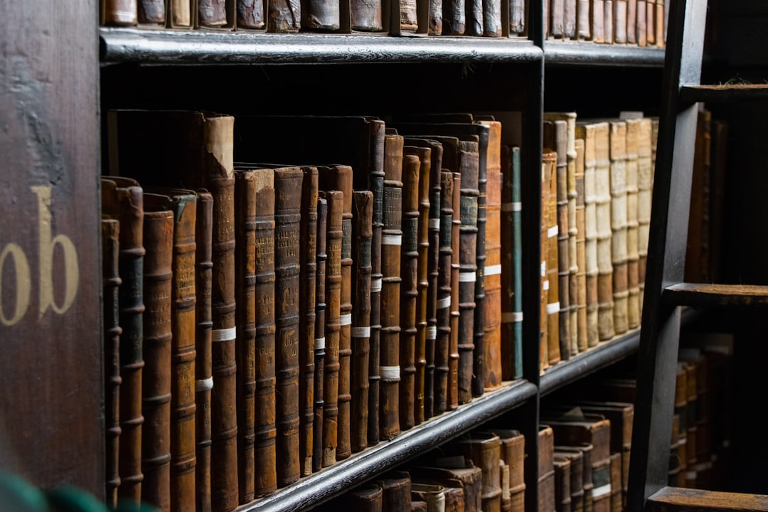 A view of a bookshelf filled with old books in a library setting.