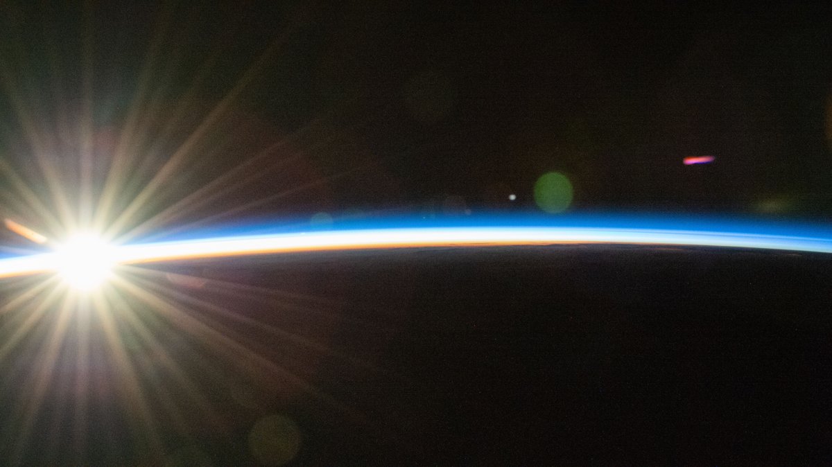 An orbital sunrise bursting over Earth's curved horizon, the blue atmospheric arc lit by a radiant new dawn, a clean conceptual image of hope and a new beginning for a world-federalism poem.