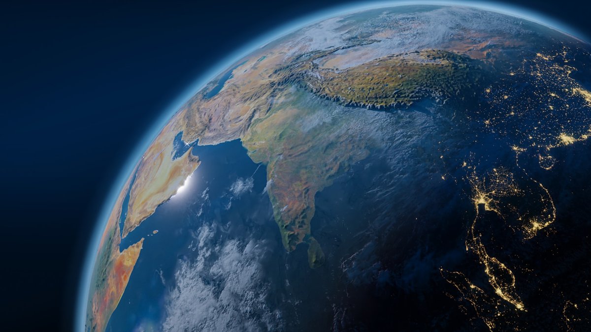 Earth seen from space, the planet's curve showing Africa, the Middle East, India and Asia with night-side city lights, a single shared world for an essay on uniting the global movement.