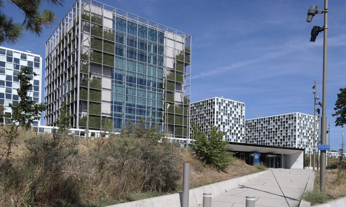 A closer, ground-level view of the International Criminal Court building in The Hague with its glazed facade and the public entrance, establishing the institution behind this 2021 caseload update.