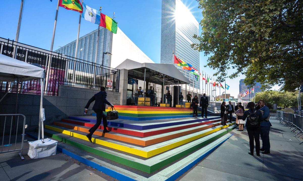 The row of member-state flags at the United Nations Headquarters plaza in New York, the community of nations gathered under shared principles that the essay describes.