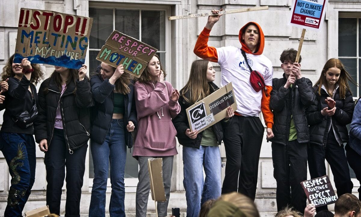 Young climate strikers at a 2019 global climate strike holding hand-made placards (Stop Melting My Future, Respect Your Mother), the youth climate-justice movement that the article's CUNCR 2019 summit and Epirus Declaration speak for.