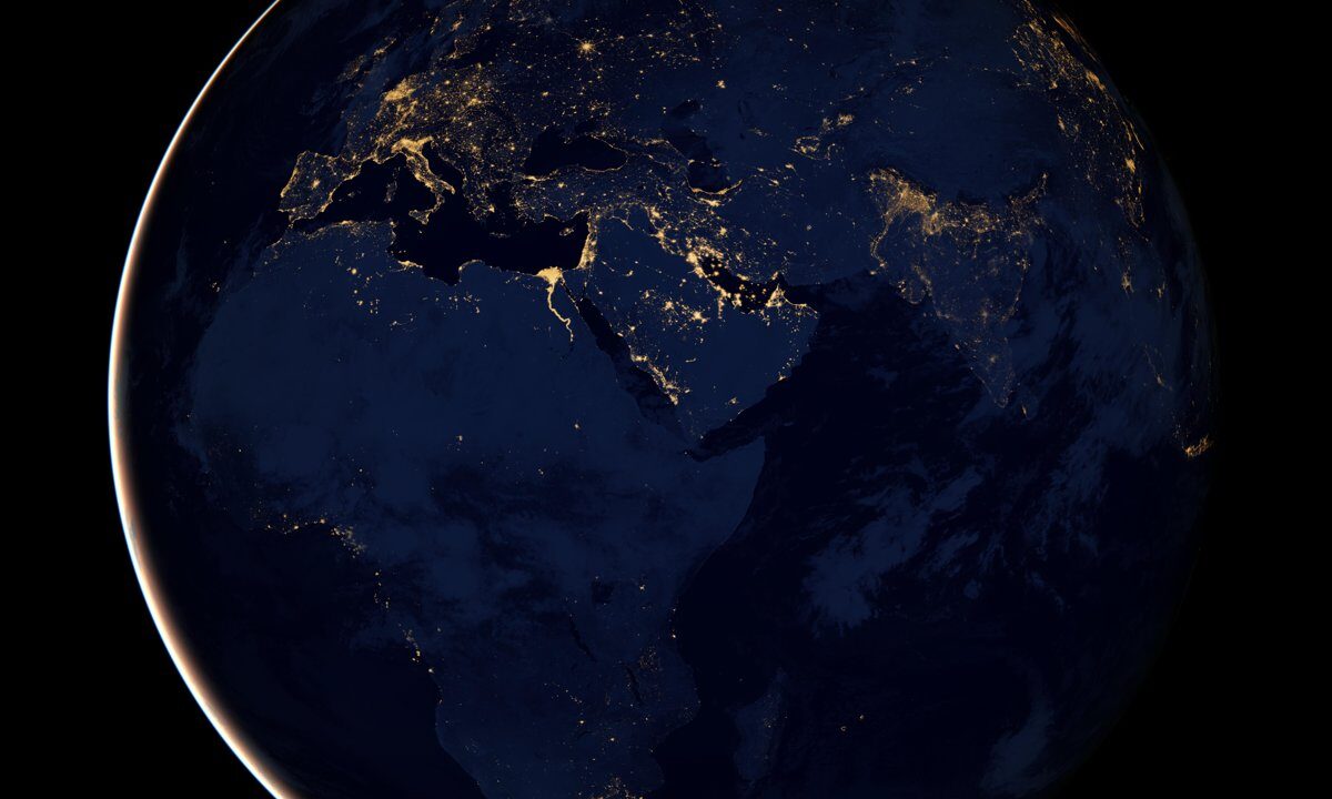 Earth at night from space (NASA Black Marble, hemisphere centered on Africa, Europe and the Middle East), city lights tracing a single interconnected, illuminated planet.
