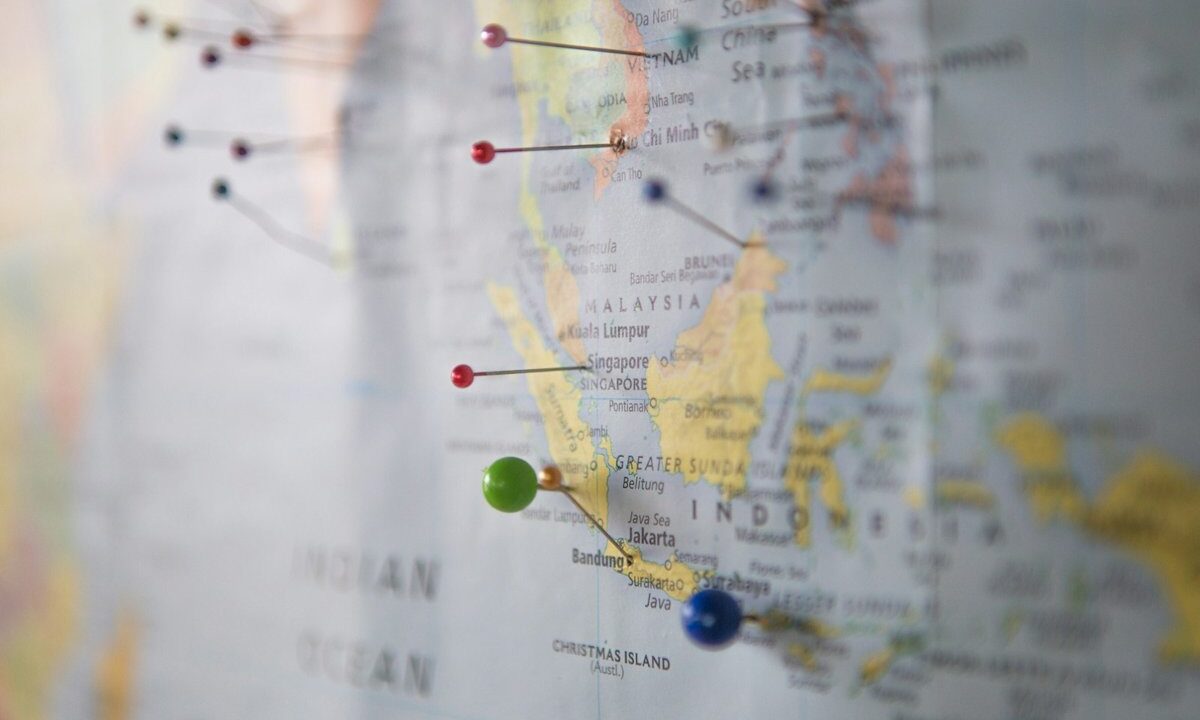 A world map studded with colored pins across many countries, a conceptual image of opinion data gathered internationally.