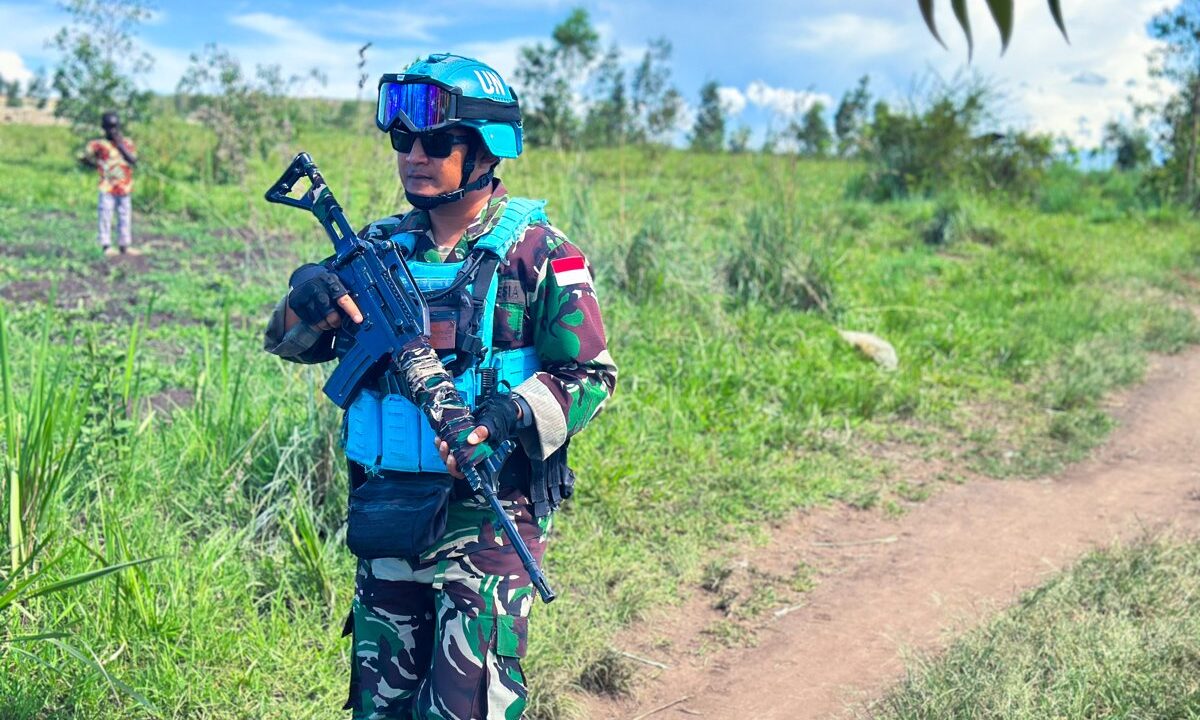 A UN peacekeeper (blue helmet) on patrol guarding a village in eastern DR Congo, the field setting of UN peacekeeping operations that the article on sexual exploitation and abuse and mobile gender courts addresses.