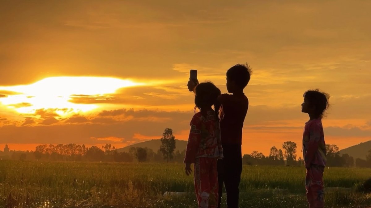 Children silhouetted against a sunset over a field, a tasteful conceptual image of the future generations whose rights and interests the proposed Special Envoy would represent.