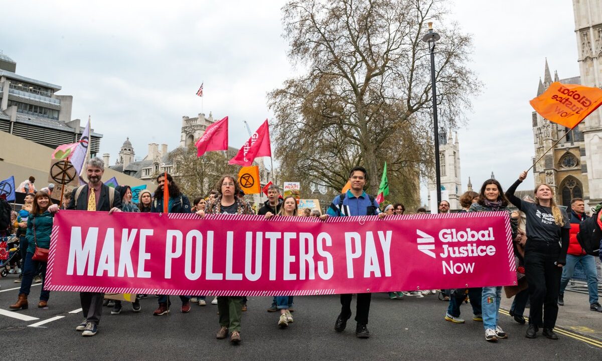 A climate-justice march carrying a large MAKE POLLUTERS PAY banner, the literal thesis of the climate litigation wave that seeks to force corporations and states to cut emissions.