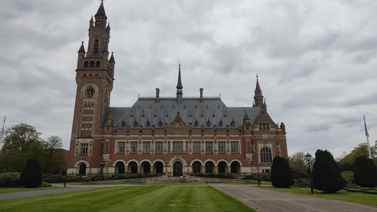 The building is a large, ornate structure with multiple towers and a central entrance, indicative of a government or leg