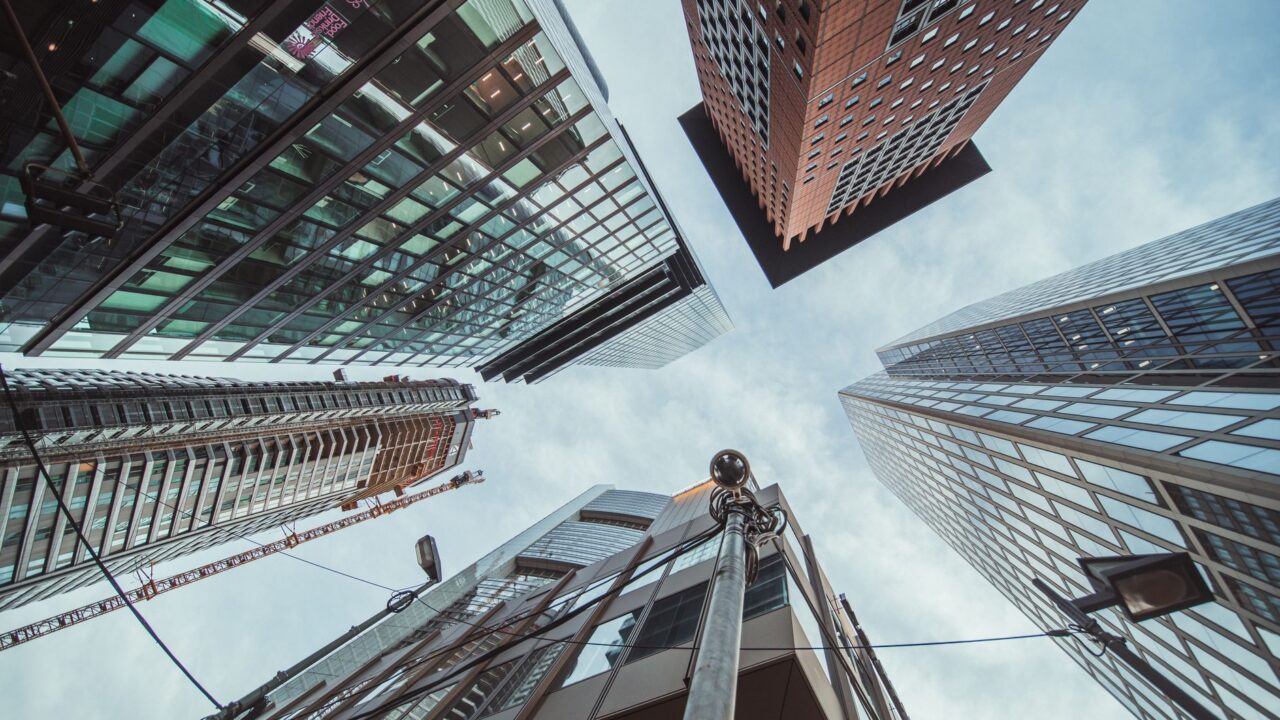 A view from below looking up at the towering skyscrapers of a city skyline.