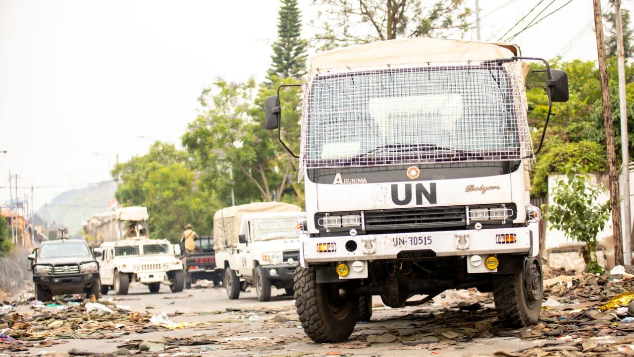 A truck driving down a road littered with waste and pollution.