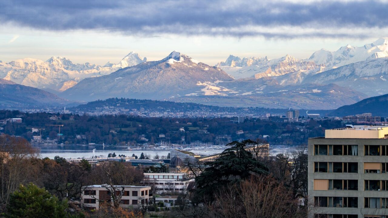 A city skyline with mountains in the distance, suggesting a location near a mountain range.