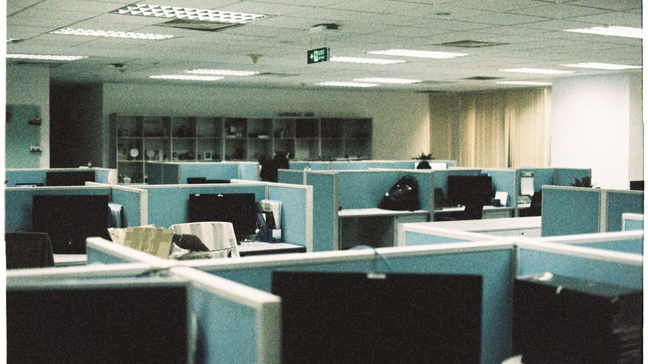An office cubicle with a computer and desk, typical of a modern workspace.