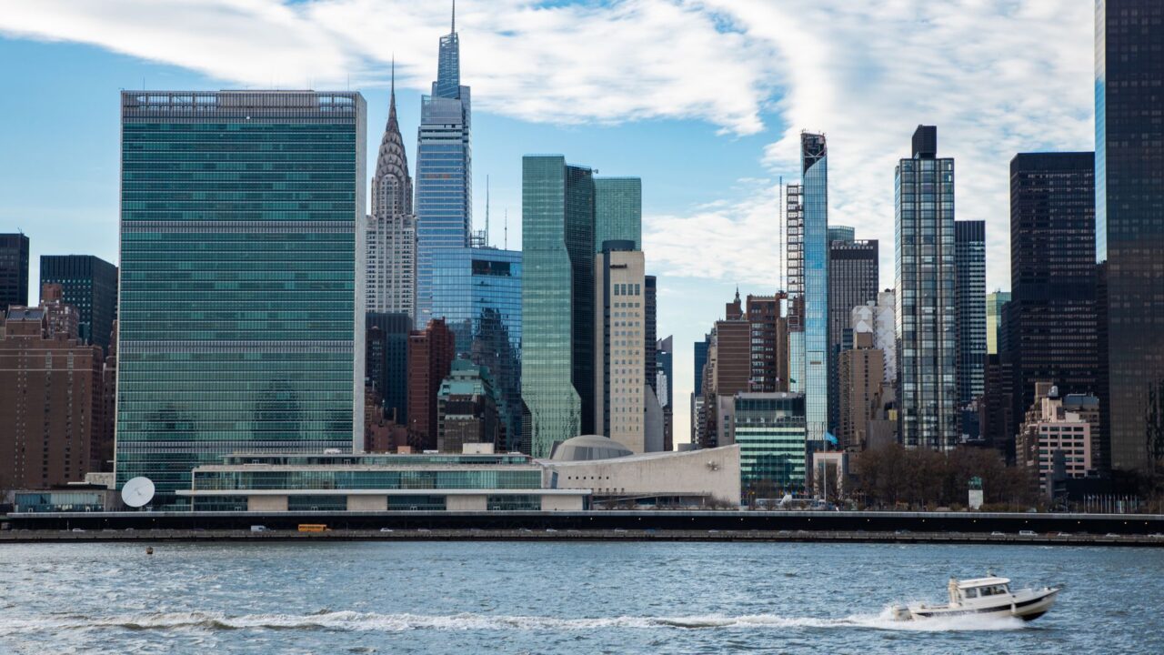 The image captures a breathtaking view of the New York City skyline, with the iconic Empire State Building and the Unite