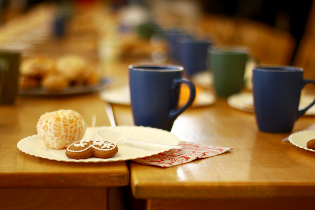 A table set for a group breakfast with coffee and pastries.