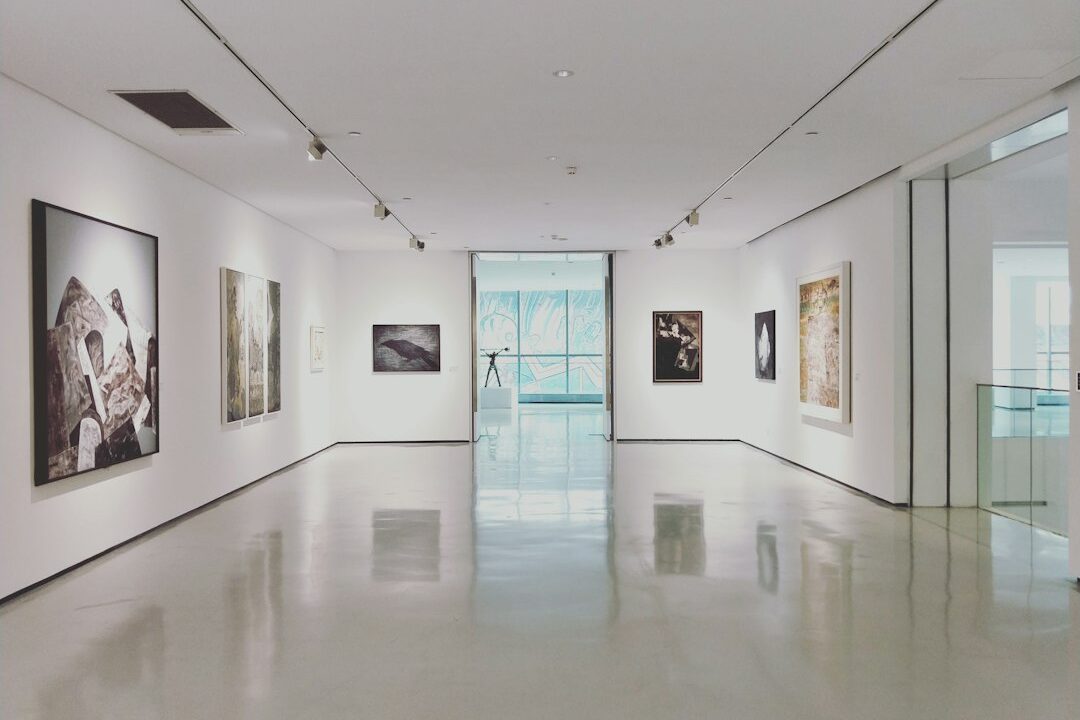 The image shows an art gallery with a variety of modern and contemporary artworks on display.