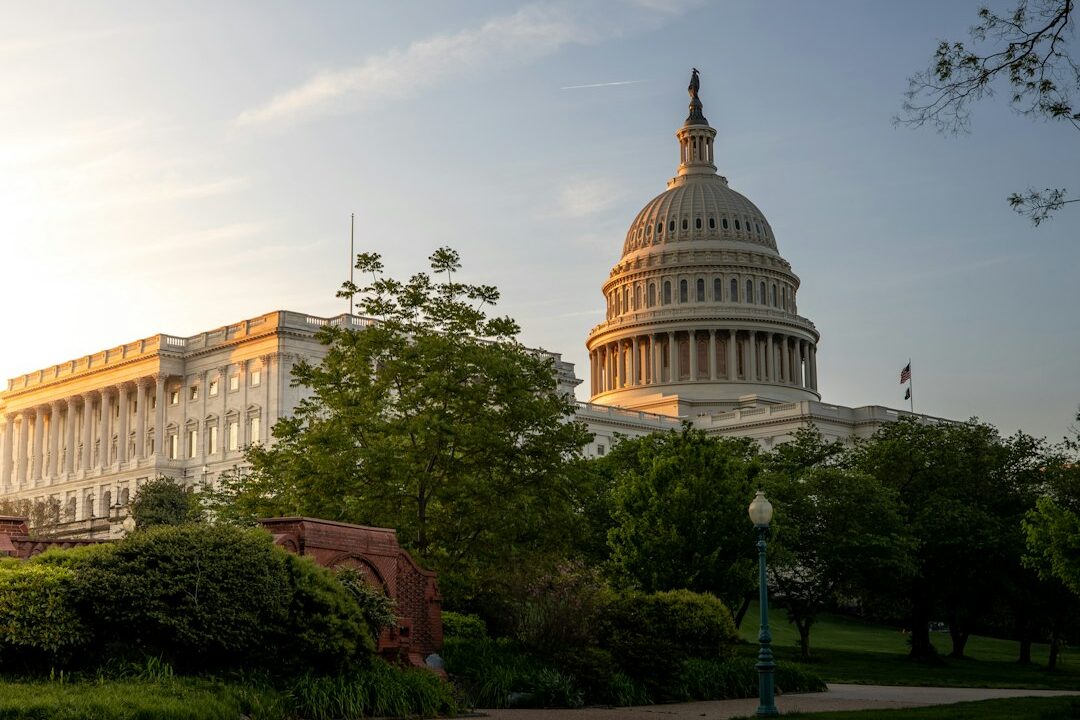 The United States Capitol building at sunset, with the iconic dome and columns illuminated against the sky.