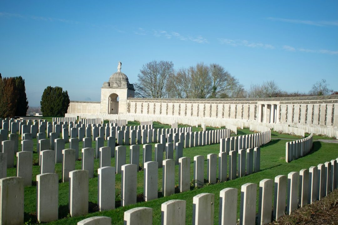 A well-maintained cemetery with white headstones and a central monument.