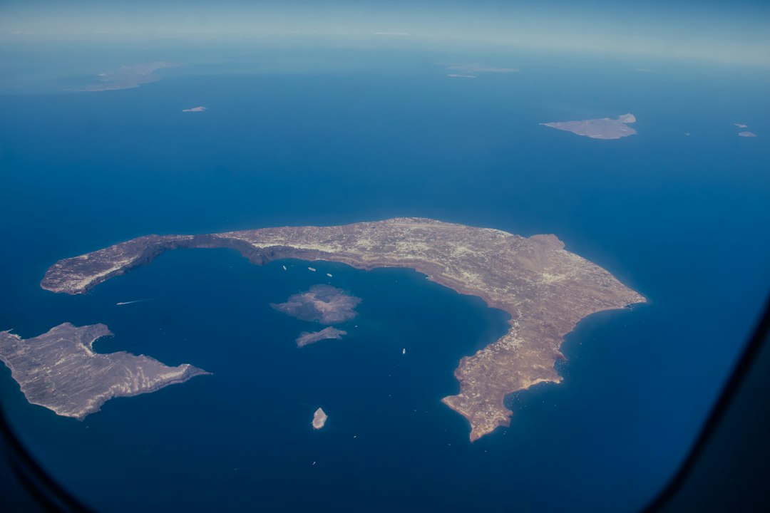 Aerial view of a coastal island with clear demarcation of land and sea.