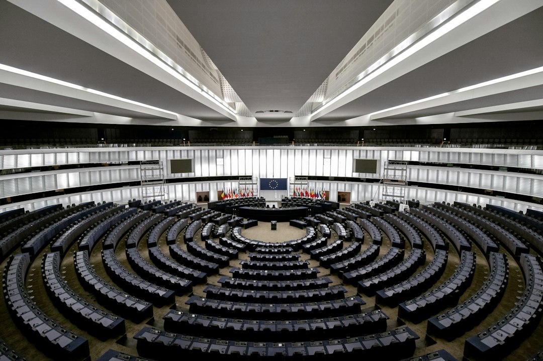 The interior of a large legislative assembly hall, with rows of seats facing a central podium.