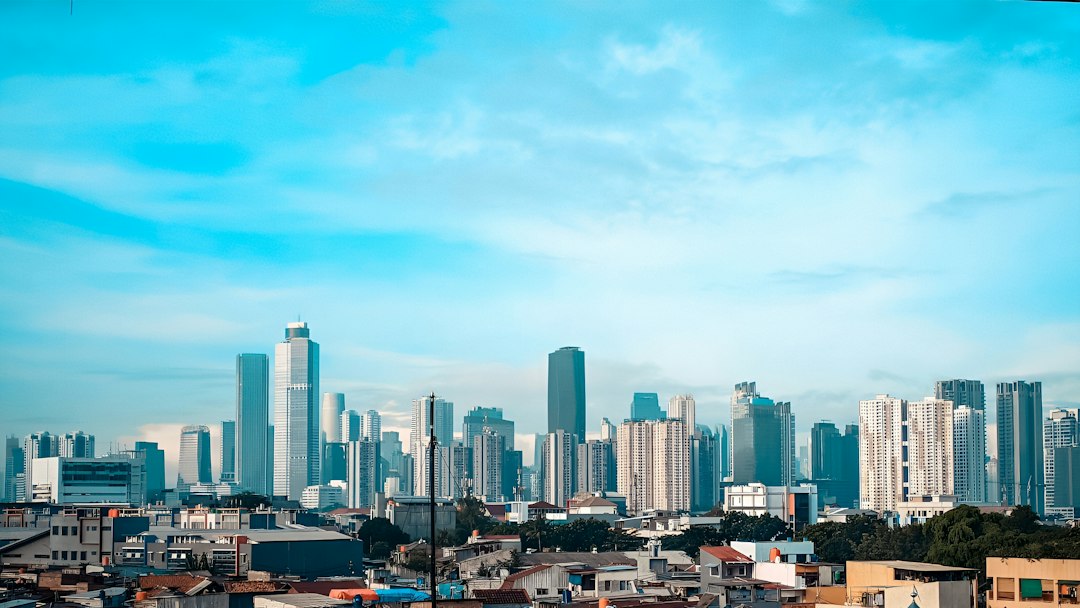 A view of a city skyline with tall buildings under a partly cloudy sky.